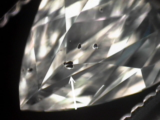 Before and after shots of a marquise diamond with black crystals. 